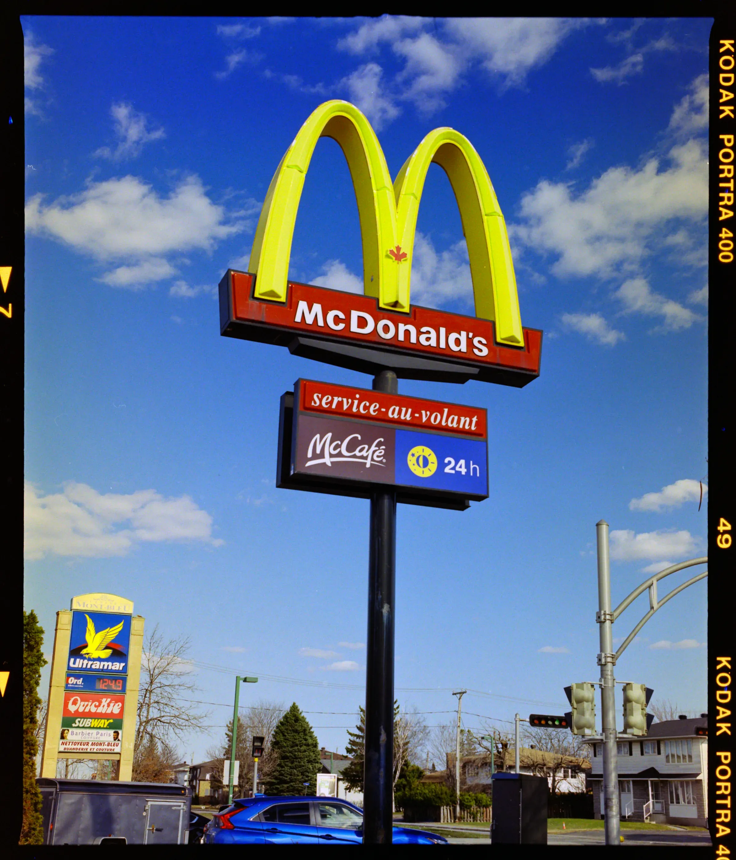 A McDonald's sign against a blue sky on Kodak Portra 400, converted by Monobath with Everyday 200
