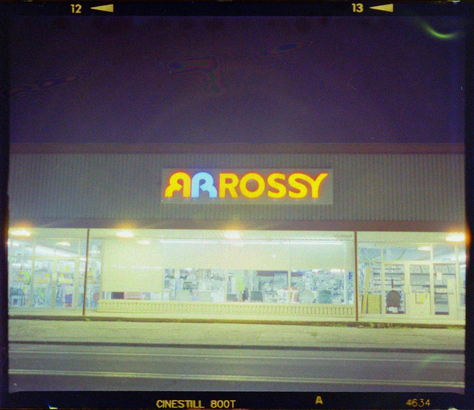 A store front lit up at night, on CineStill 800T, converted with Night 800