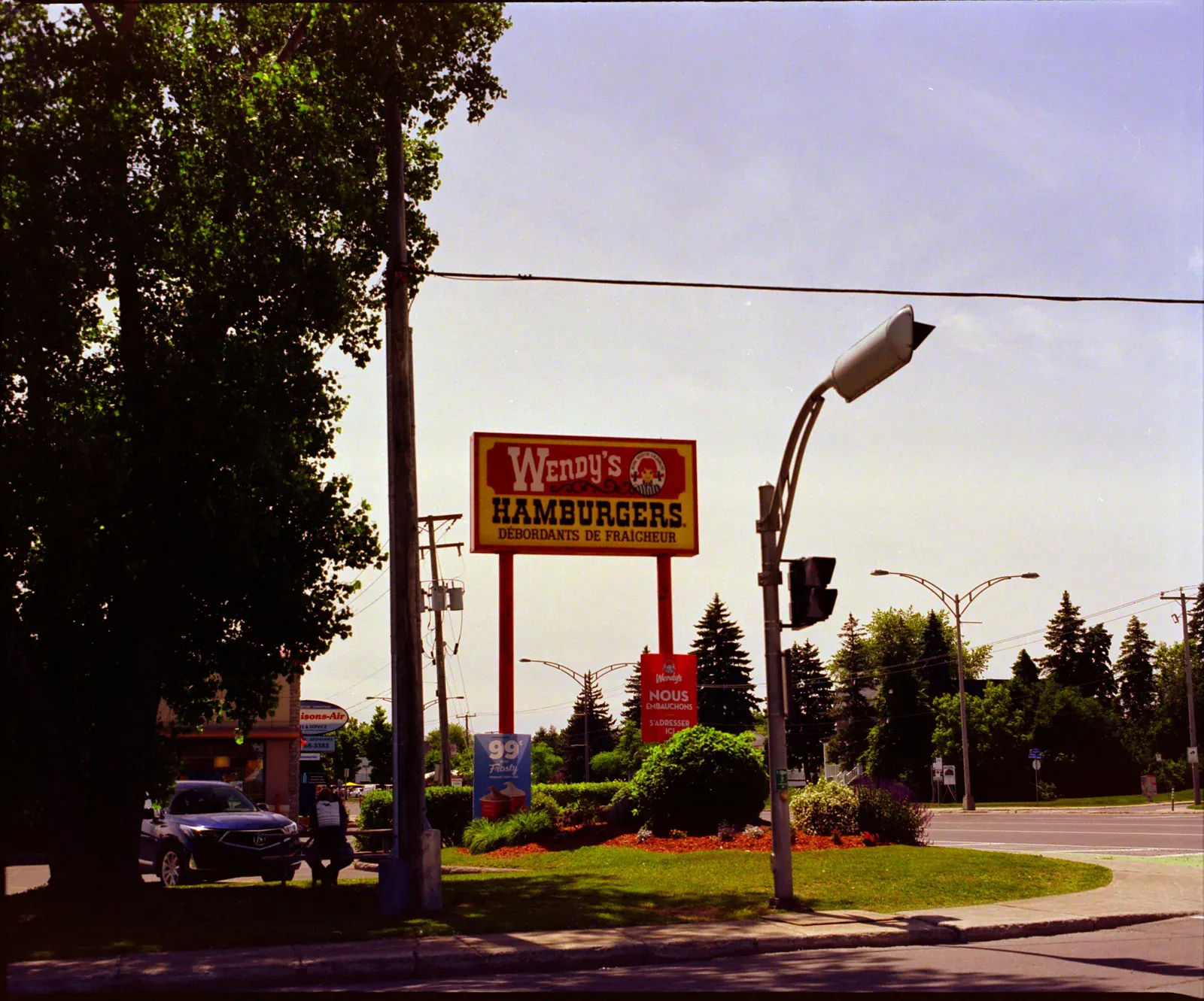 A Wendy's hamburgers sign by a road, converted with Reference 100